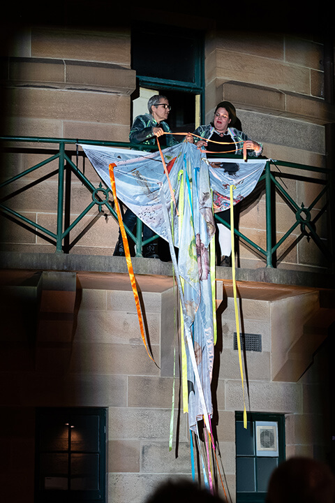 Linda Dement and Nancy Muro-Flude performing the bedsheet as a flag