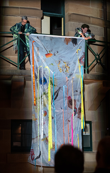 Linda Dement and Nancy Muro-Flude performing the bedsheet as a flag